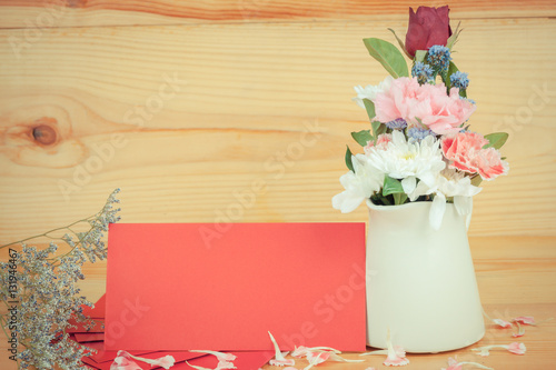 Vase with flowers and envelopes on wooden