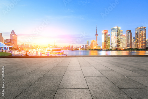 Empty floor with modern skyline and buildings at sunset in Shanghai