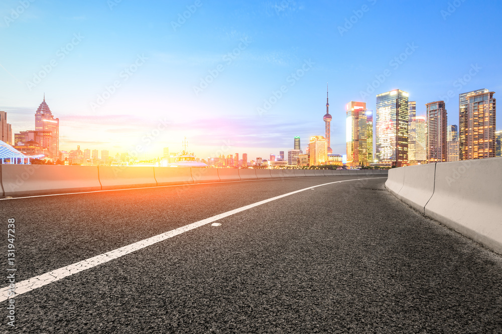 Asphalt road and modern cityscape at sunset in Shanghai