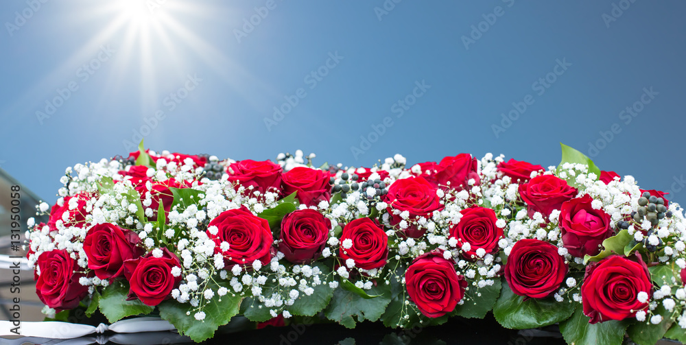 ein festliches Blumengebinde aus Rosen und Schleierkraut für eine