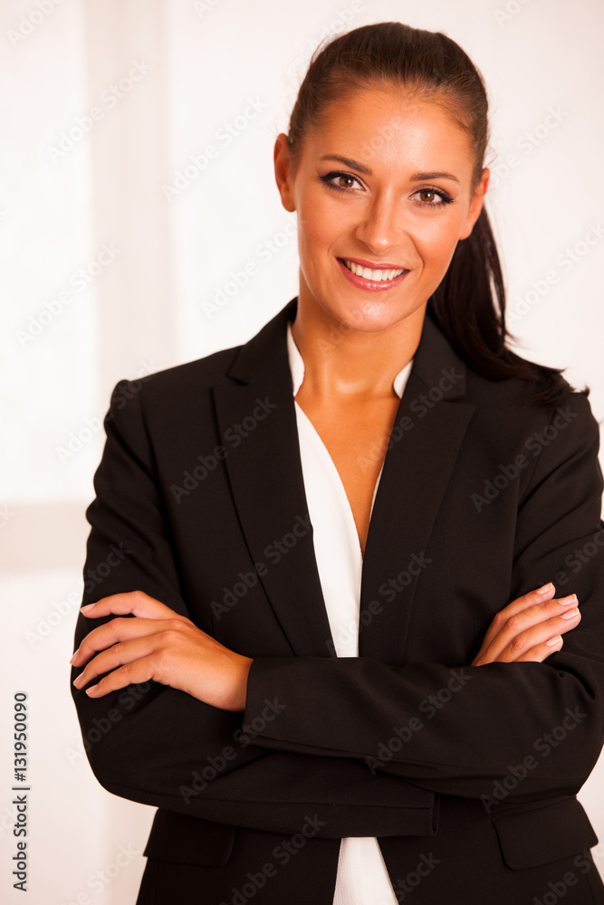 Business woman in the office gesturing confidence with arms cros Business woman in the office gesturing confidence with arms cros