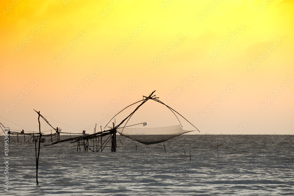Silhouette of traditional fishing method using a bamboo square dip
