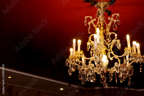 Beautiful crystal chandelier on black ceiling photo