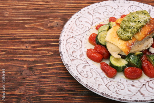 Tasty baked chicken breasts which basil pesto sauce, tomatoes, and cheese. Healthy eating concept.