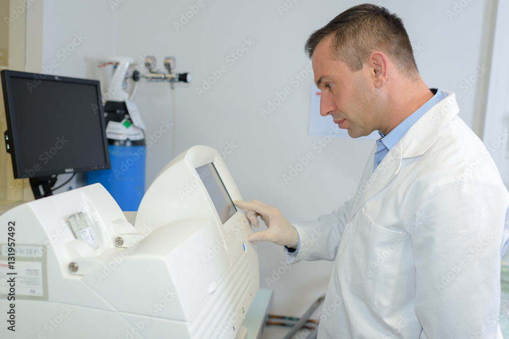 Man in white jacket programming machine Man in white jacket programming machine
