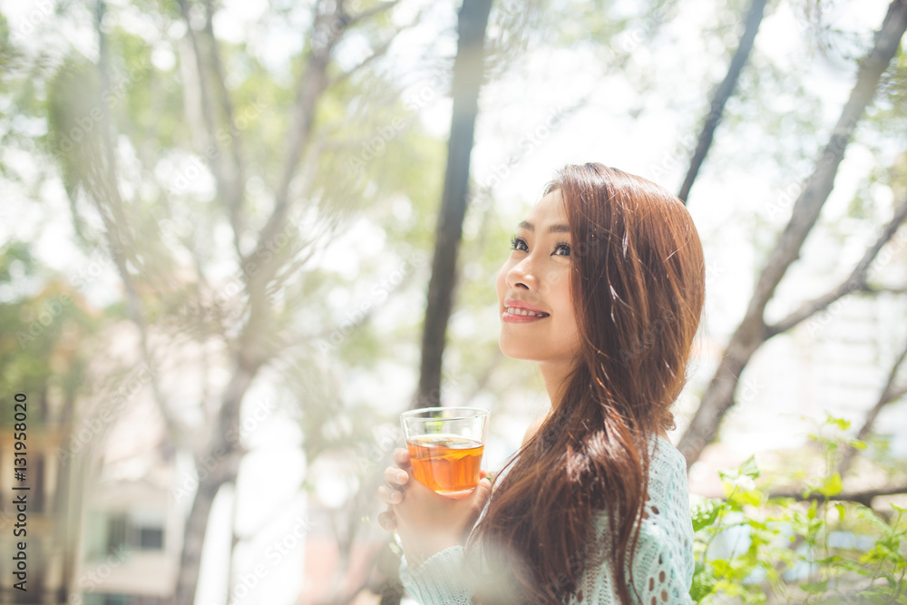 Portrait of a young asian woman drinking her morning tea. Fell r Portrait of a young asian woman drinking her morning tea. Fell r