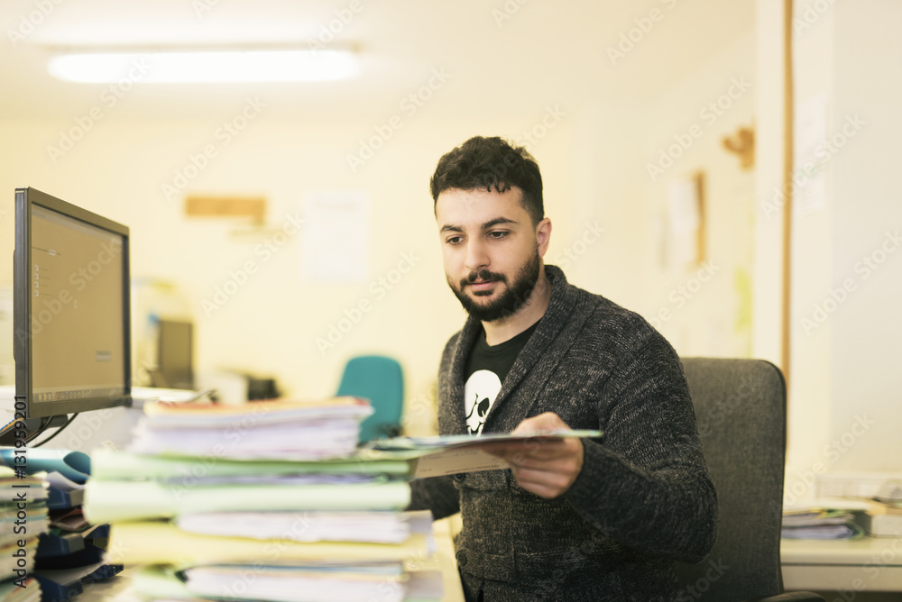 Bearded office clerk working with files Bearded office clerk working with files