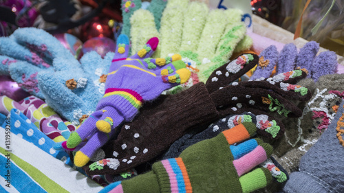 Group of handmade colorful knitted socks, mittens, gloves and hats in the market.