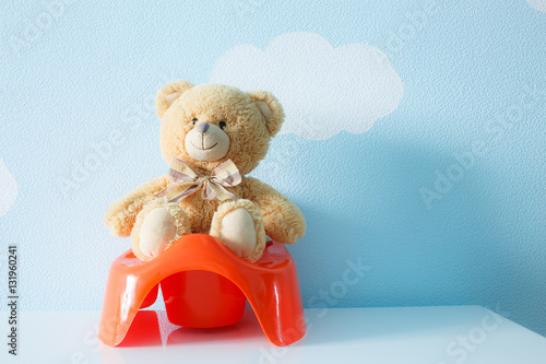 Foto Cute toy sitting on the potty
