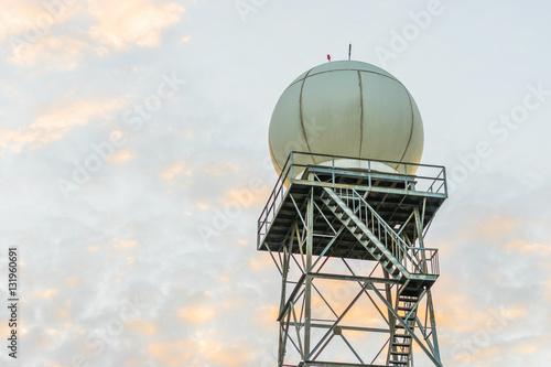 A doppler weather radar at sunset against a blue sky background. Copy space on top.
