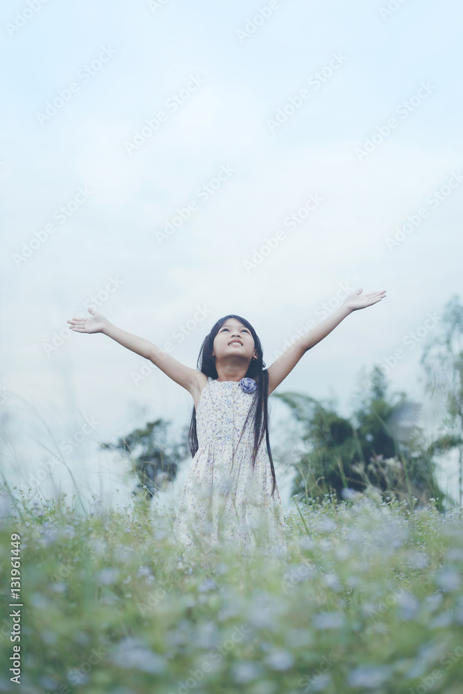 Cute Asian Girl raised hand at meadow happily. Cute Asian Girl raised hand at meadow happily.