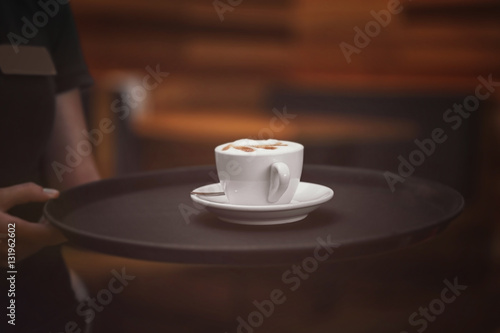 Fototapeta Naklejka Na Ścianę i Meble -  Cup of tasty cappuccino on waiter tray