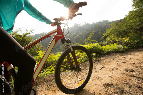 Fototapeta Naklejka Na Ścianę i Meble -  riding mountain bike at sunrise forest trail