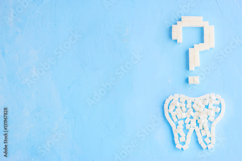 Question mark made of sugar cubes on blue background, symbol