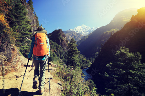 young woman backpacker trekking at the himalaya mountains