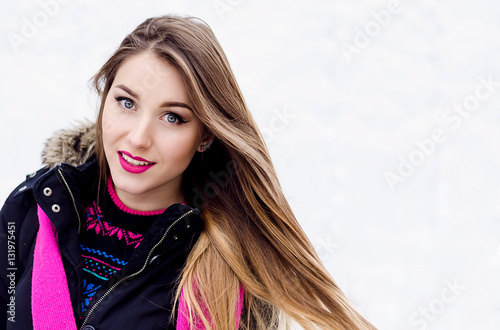 Young lady with long blonde hair and perfect makeup looking at the camera and smiling, outdoor shooting in the city. Winter look in stylish clothes.Close up portrait on white backgroundYoung lady with photo