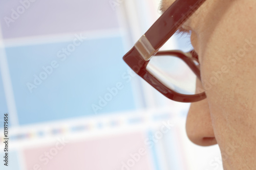 Man with glasses looking inspecting a test print photo