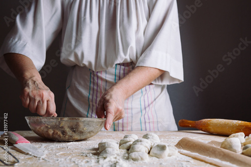 Front view of woman's hands making meat stuffing for dumplings.