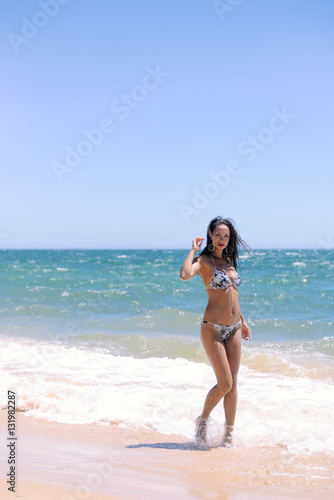 Playful joyful woman with perfect body relaxing feeling free, having fun on tropical beach vacation