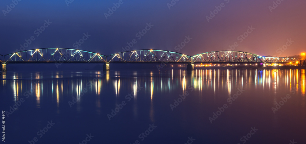 Fototapeta premium Panoramic view of road bridge over Vistula river in the night. Torun, Poland.