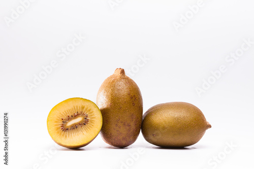 Whole and cut golden kiwi fruit on white