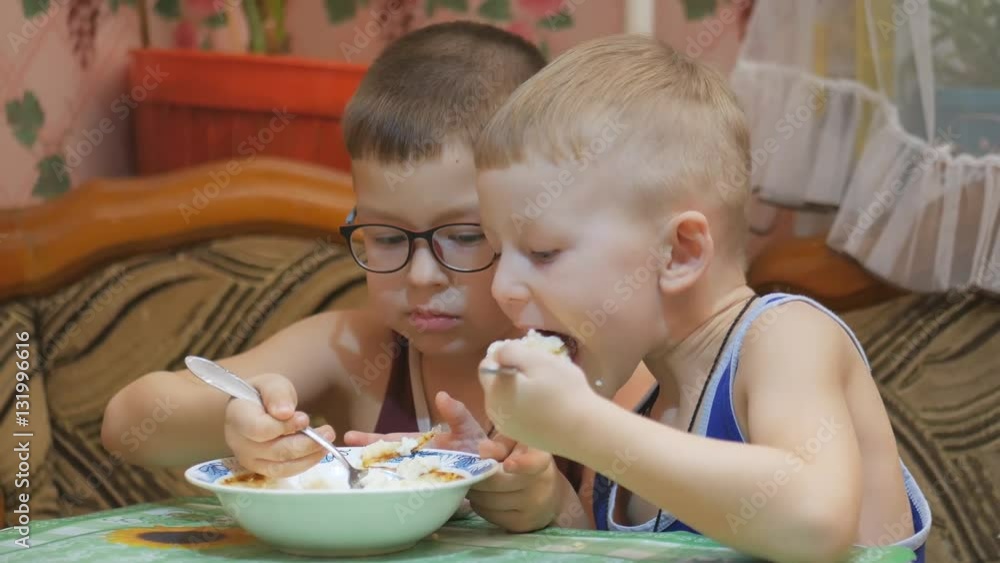Children eat with appetite at the table. Children eat with appetite at the table.