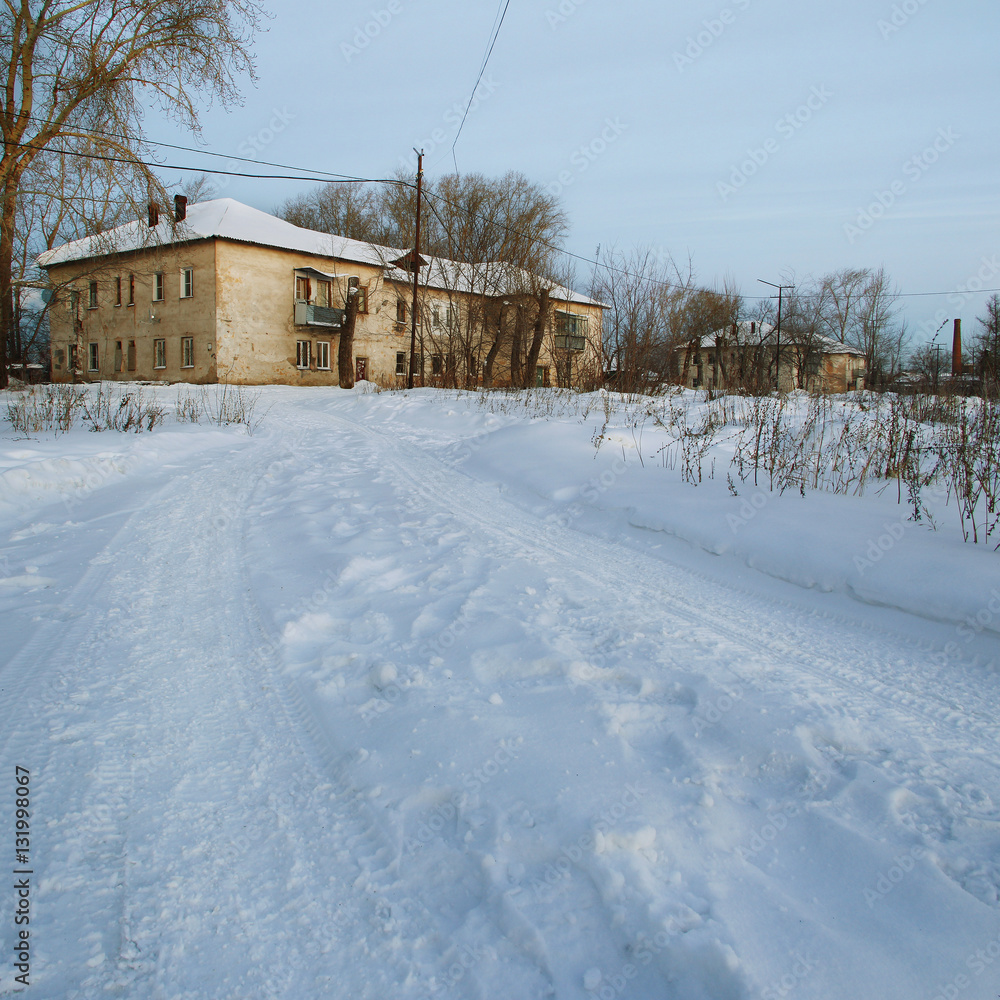 View of the winter road and old two-storeyed house