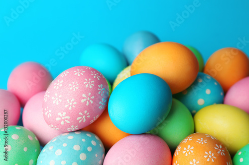 Colorful Easter eggs on blue background, closeup