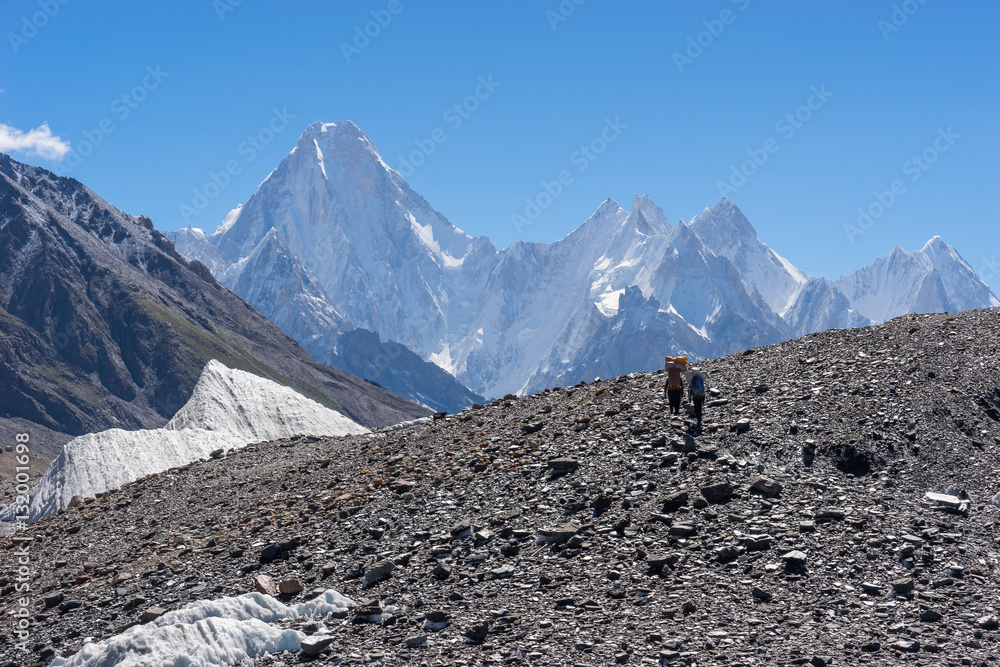 Fototapeta premium Two porters walk toward to Concordia camp, K2 trek, Pakistan