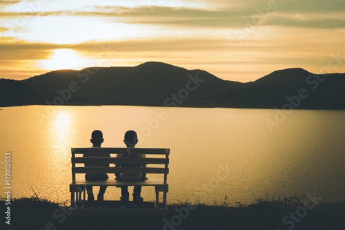 young Asian child, selective focus, vintage, the silhouette of boys sitting looking sunset
