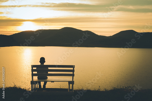 The silhouette of boy sitting alone, concept of lonely, sad, alone, person space, alone and scared