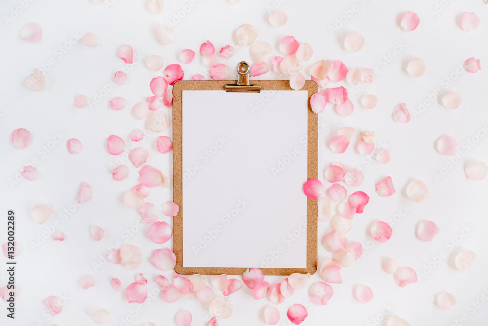 Clipboard mock up and pink rose petals pattern. Flat lay, top view Clipboard mock up and pink rose petals pattern. Flat lay, top view