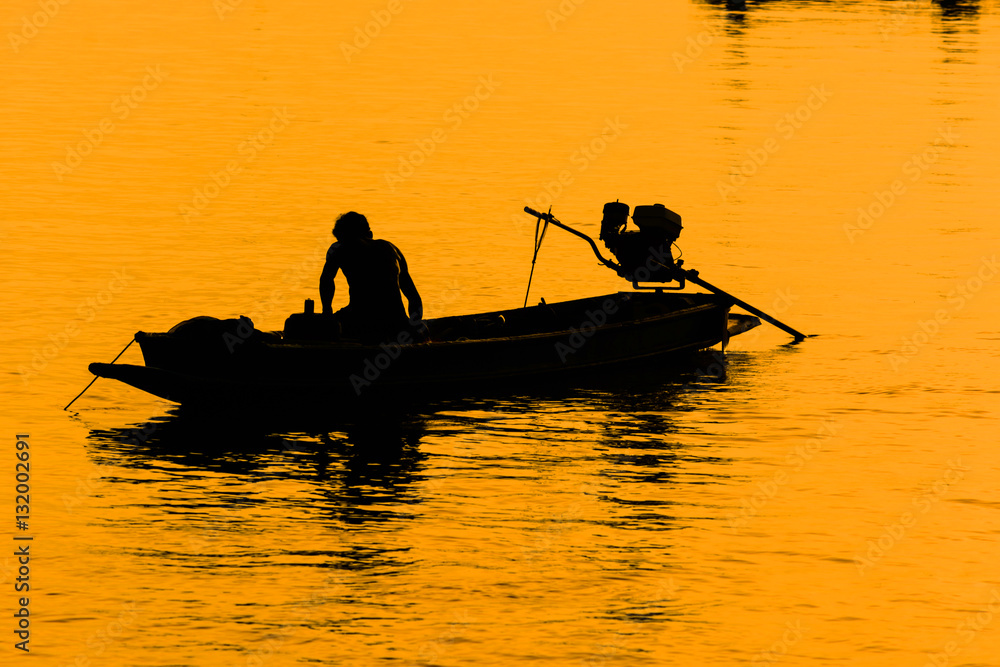 Silhouette of man paddling boat at sunset.. Bangtabun ,Phetchabu