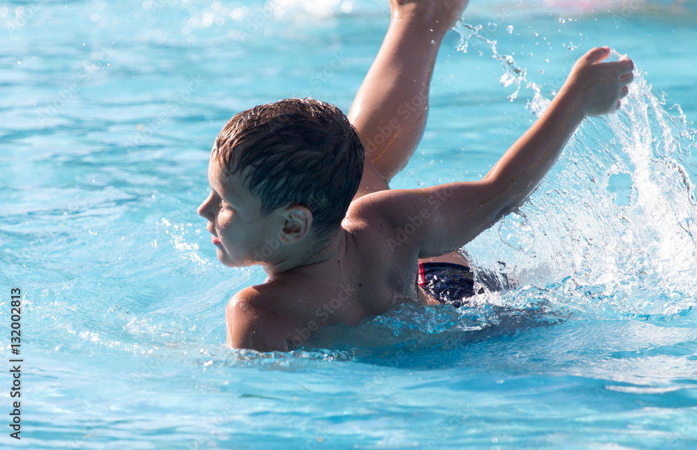 boy swims with a splash in the water park