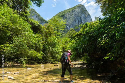 Woman trekking through small stream at Mulu National Park 