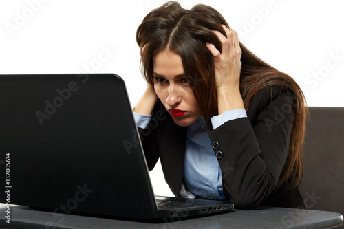 Frustrated young businesswoman at her laptop