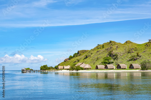 Pier and wooden bungalows tropical island Kanawa in Indonesia. photo