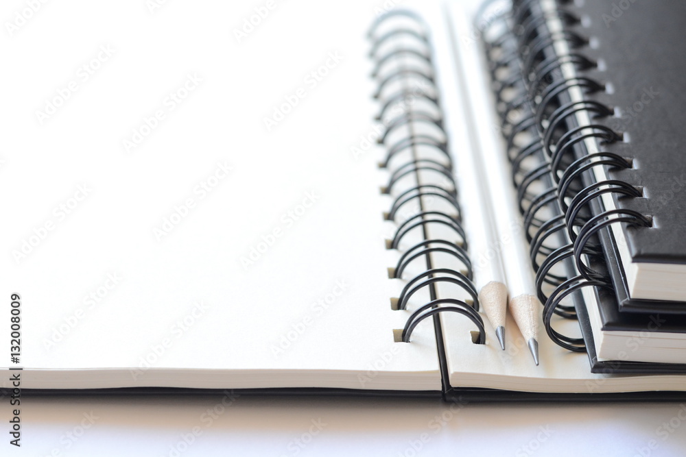 White pencils and books on blank note books with copy space for text,high key tone. White pencils and books on blank note books with copy space for text,high key tone.