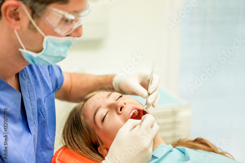 Young woman doing dental treatment - Girl having annual check visit by dentist