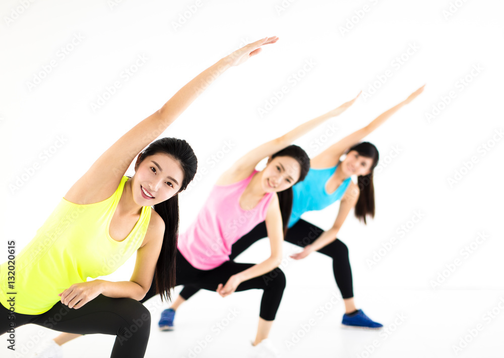 smiling young fit group stretching in gym smiling young fit group stretching in gym