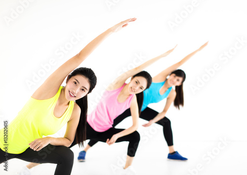 smiling young fit group stretching in gym