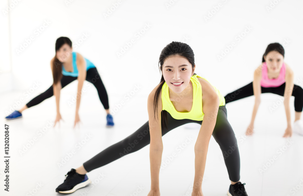 smiling young fit group stretching in gym smiling young fit group stretching in gym