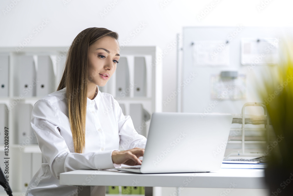 Girl in white blouse is typing in office Girl in white blouse is typing in office