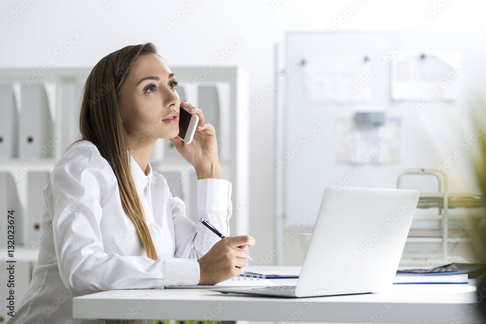 Woman on her phone with a pencil in hand Woman on her phone with a pencil in hand