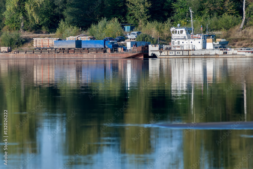 Fototapeta premium near Malmyzh, Russia - September 3, 2009: The car ferry sails away from the coast to cross the Vyatka River