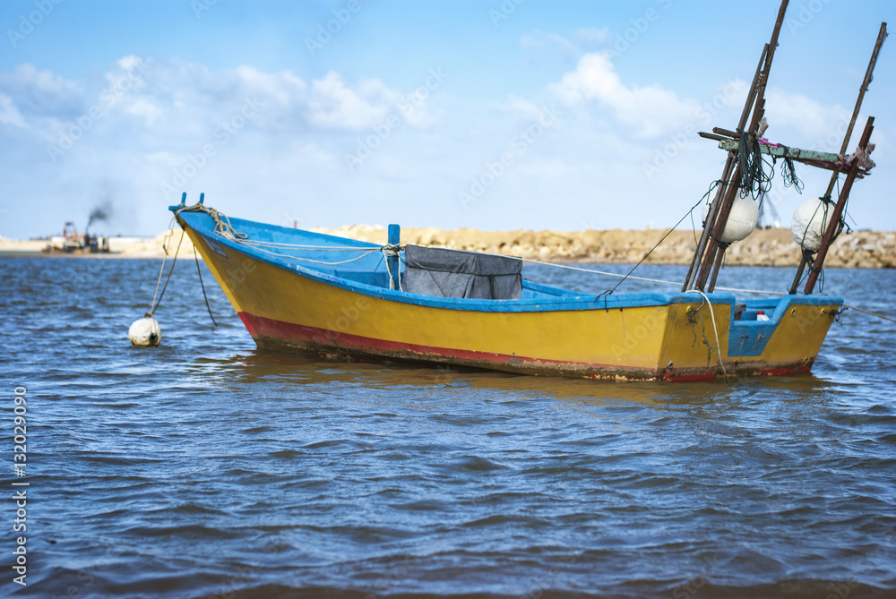 surface level shoot, yellow fisherman fibie boat moored.reflecti surface level shoot, yellow fisherman fibie boat moored.reflecti