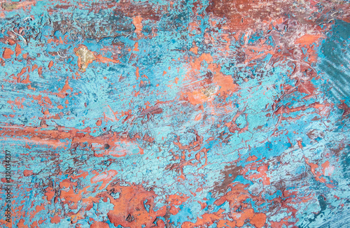 Grunge texture, blue and orange paint peeling from fiberglass su