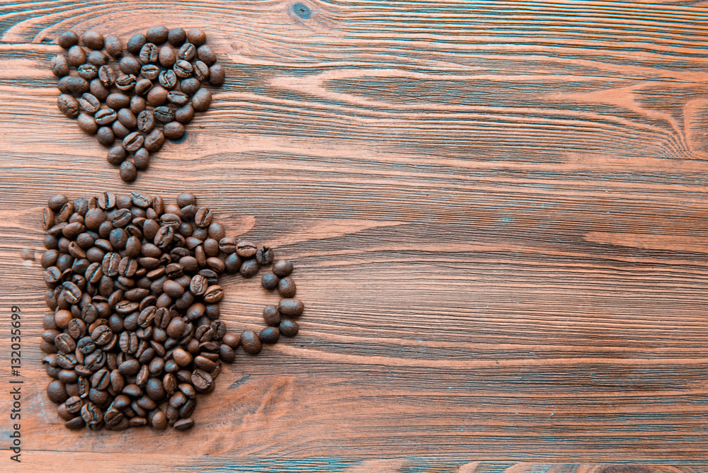 Coffee cup made from beans, grain with heart on wooden background. Valentine's Day or Wedding, love, black, frame. shaped . in shape of Coffee cup made from beans, grain with heart on wooden background. Valentine's Day or Wedding, love, black, frame. shaped . in shape of