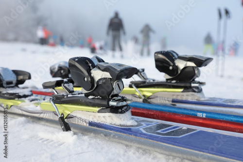 Detailed view of the ski bindings and skis lying on the piste photo