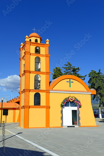 Colorful Church with blue sky background located near borders of Veracruz and Puebla, close to Pico de Orizaba, Iztaccihuatland Popocatepetl volcanoes, Mexico photo